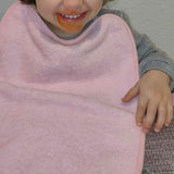 Pack of 3 terry cloth bibs for daycare in pink with elastic. Washable, terry exterior and waterproof backing. Dimensions: 33x29cm